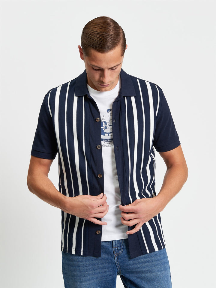 Ben Sherman Button Through Stripe Polo in Dark Navy - model wearing front view showing pique stripe design with full button placket and white stripe detail