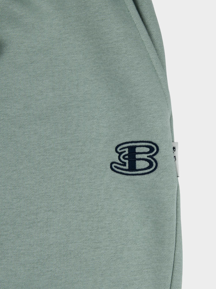 Close-up of embroidered Ben Sherman logo on agave green fleece jogger shorts - premium quality fabric detail