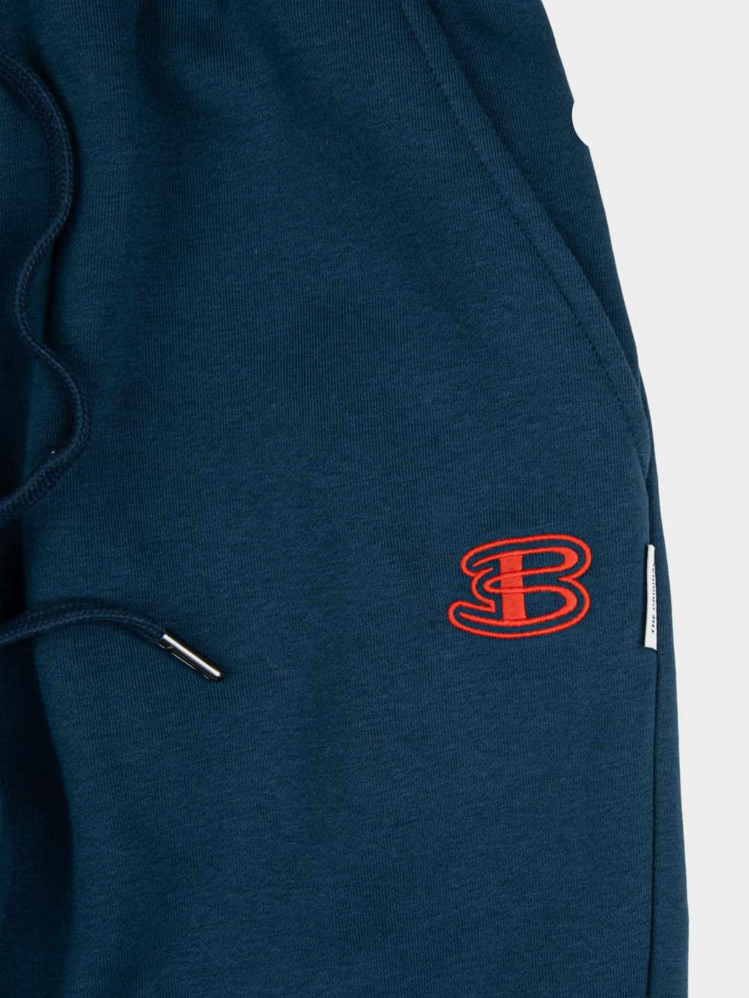 Close-up of embroidered Ben Sherman logo on indigo fleece jogger shorts - premium quality fabric and drawstring detail