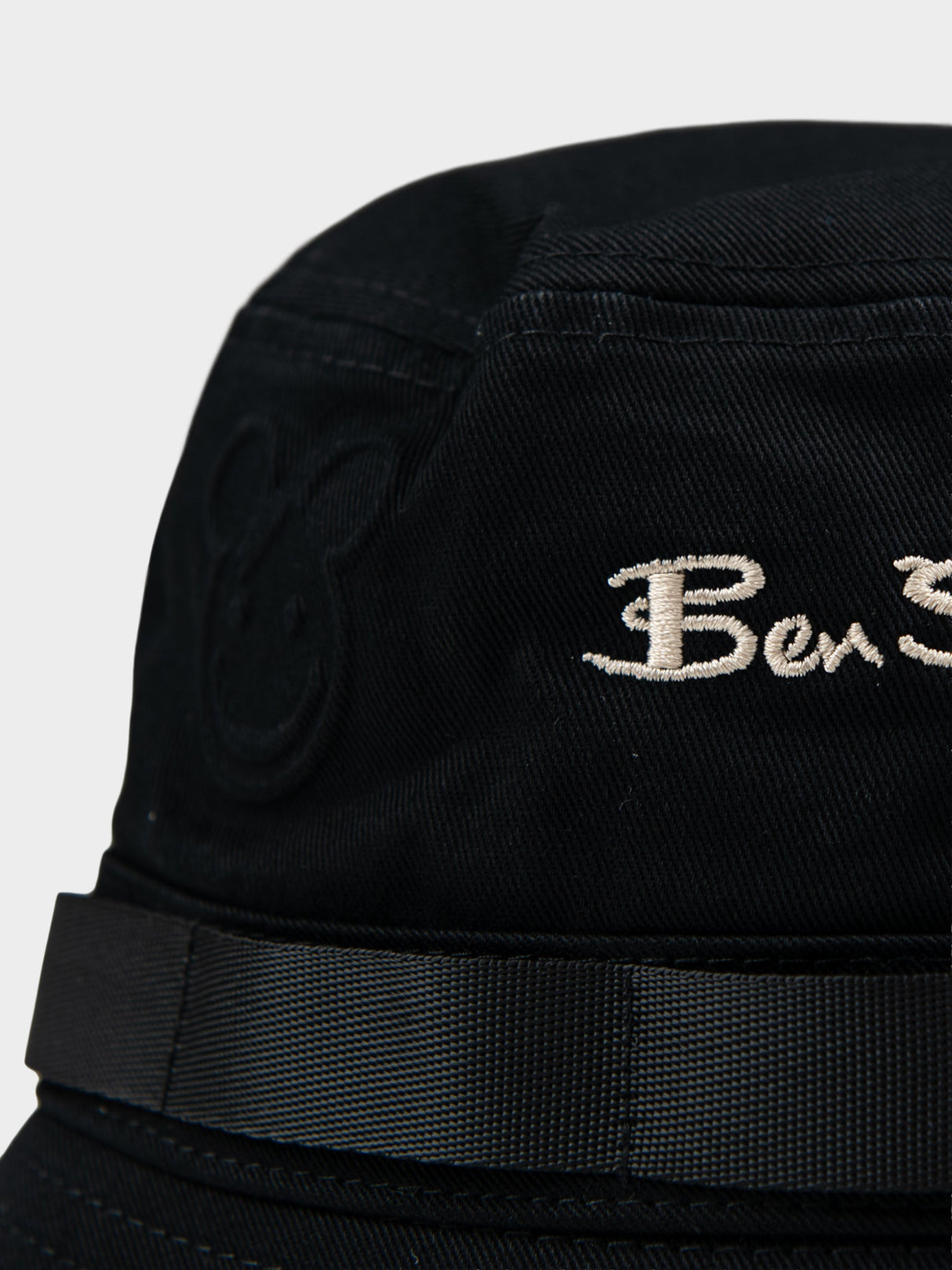 Close-up of Ben Sherman embroidered logo and bear motif emboss detail on black bucket hat