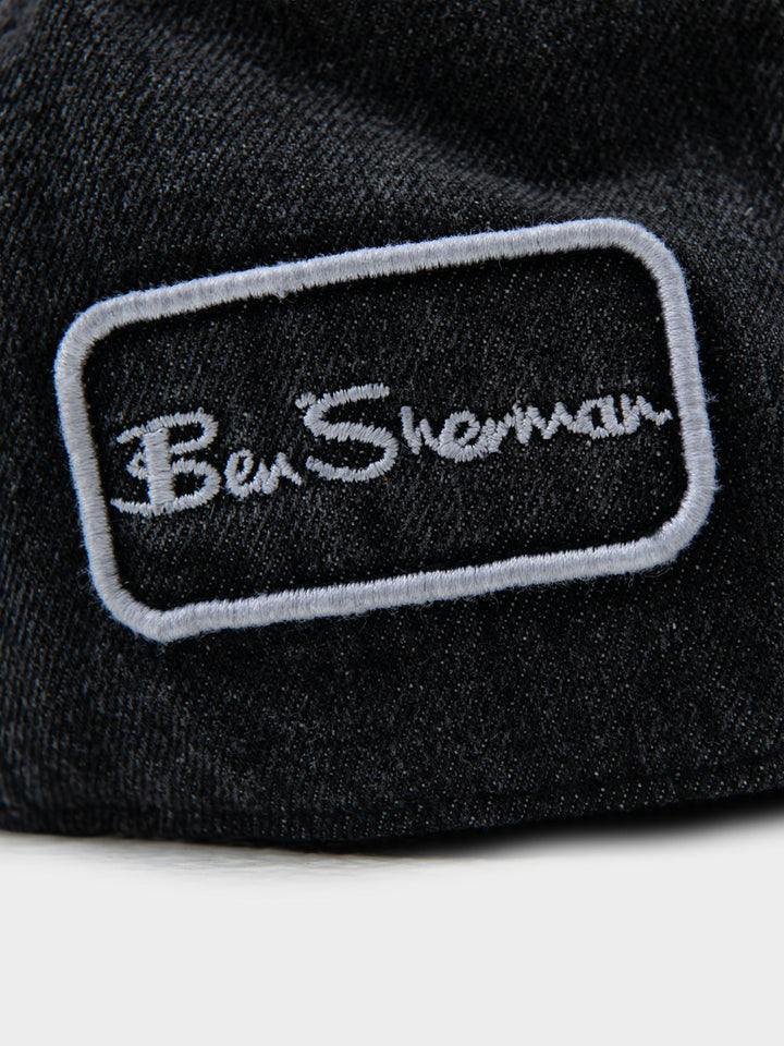 Close-up of Ben Sherman embroidered logo patch on black denim Dixie Cap