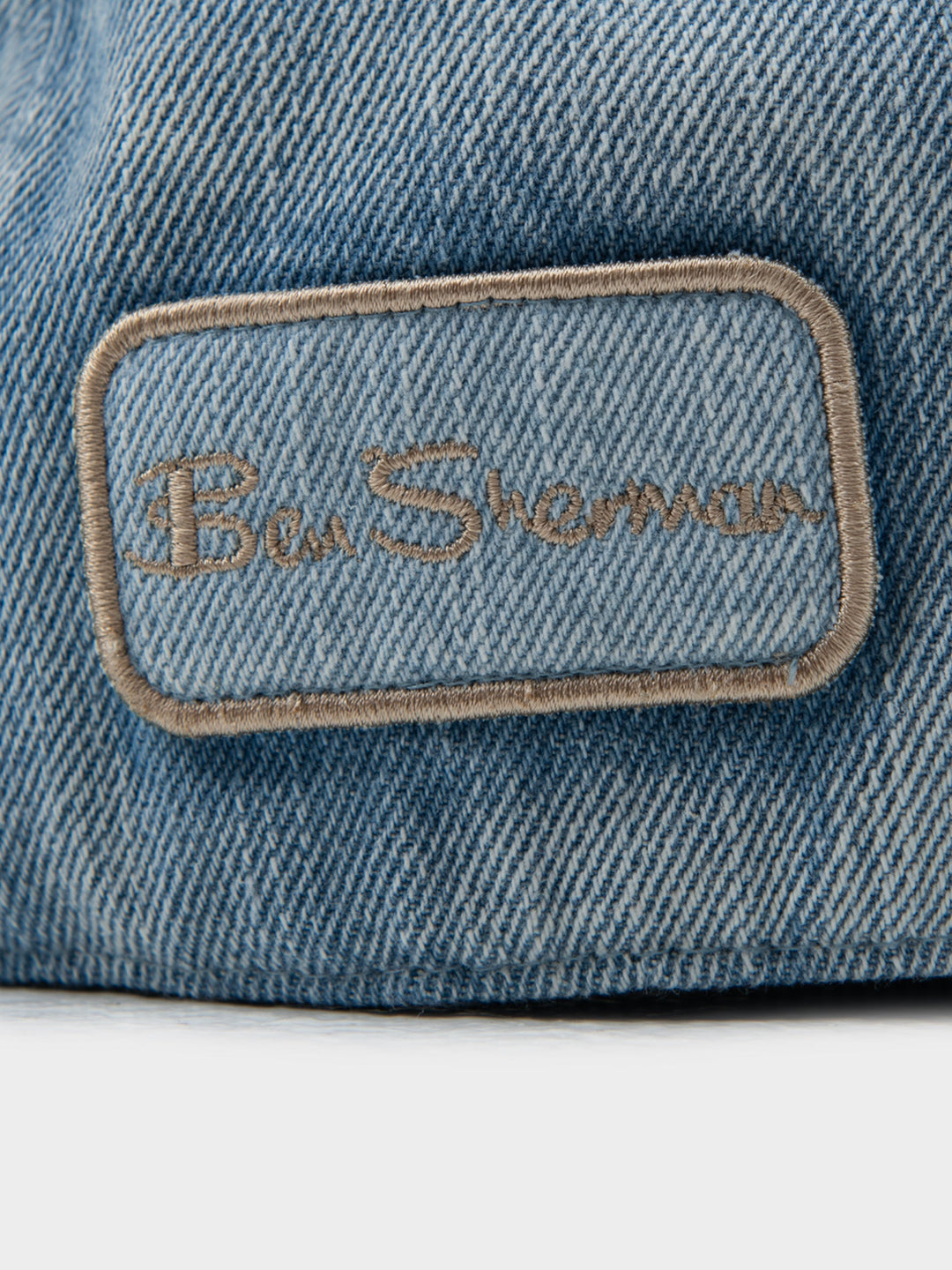 Close-up of Ben Sherman embroidered logo patch on light blue denim Dixie Cap