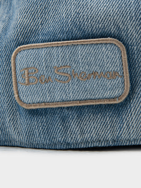 Close-up of Ben Sherman embroidered logo patch on light blue denim Dixie Cap