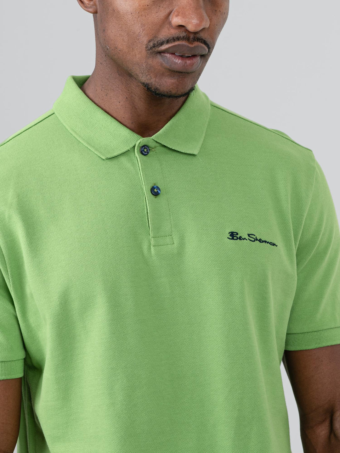 Ben Sherman Ben Polo in Piquant Green - model wearing side angle view showing flat knit collar and short sleeve detail