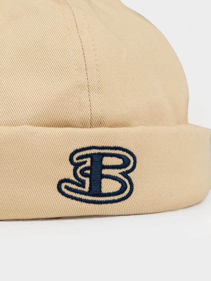 Ben Sherman Docker Hat New Wheat — close-up side view of embroidered navy B logo on cuffed cotton brim