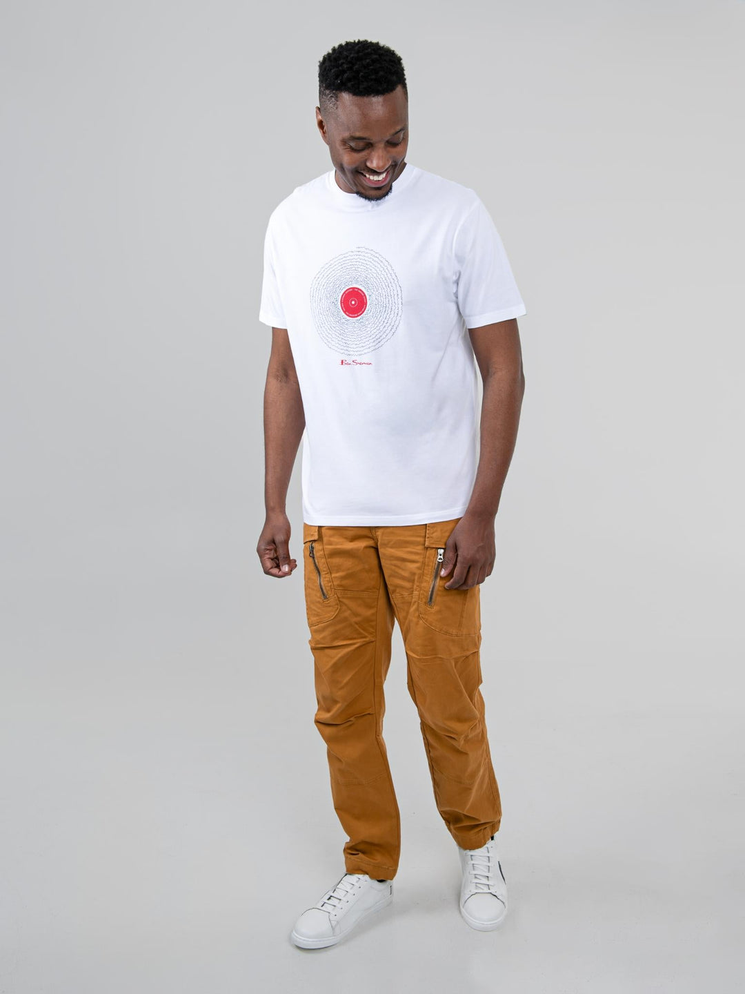 Model wearing Ben Sherman camel cargo pants styled with a white graphic tee - full outfit look