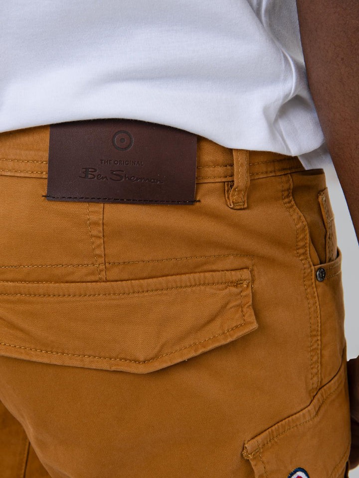 Back detail of Ben Sherman camel cargo pants showing leather branding label on back pocket