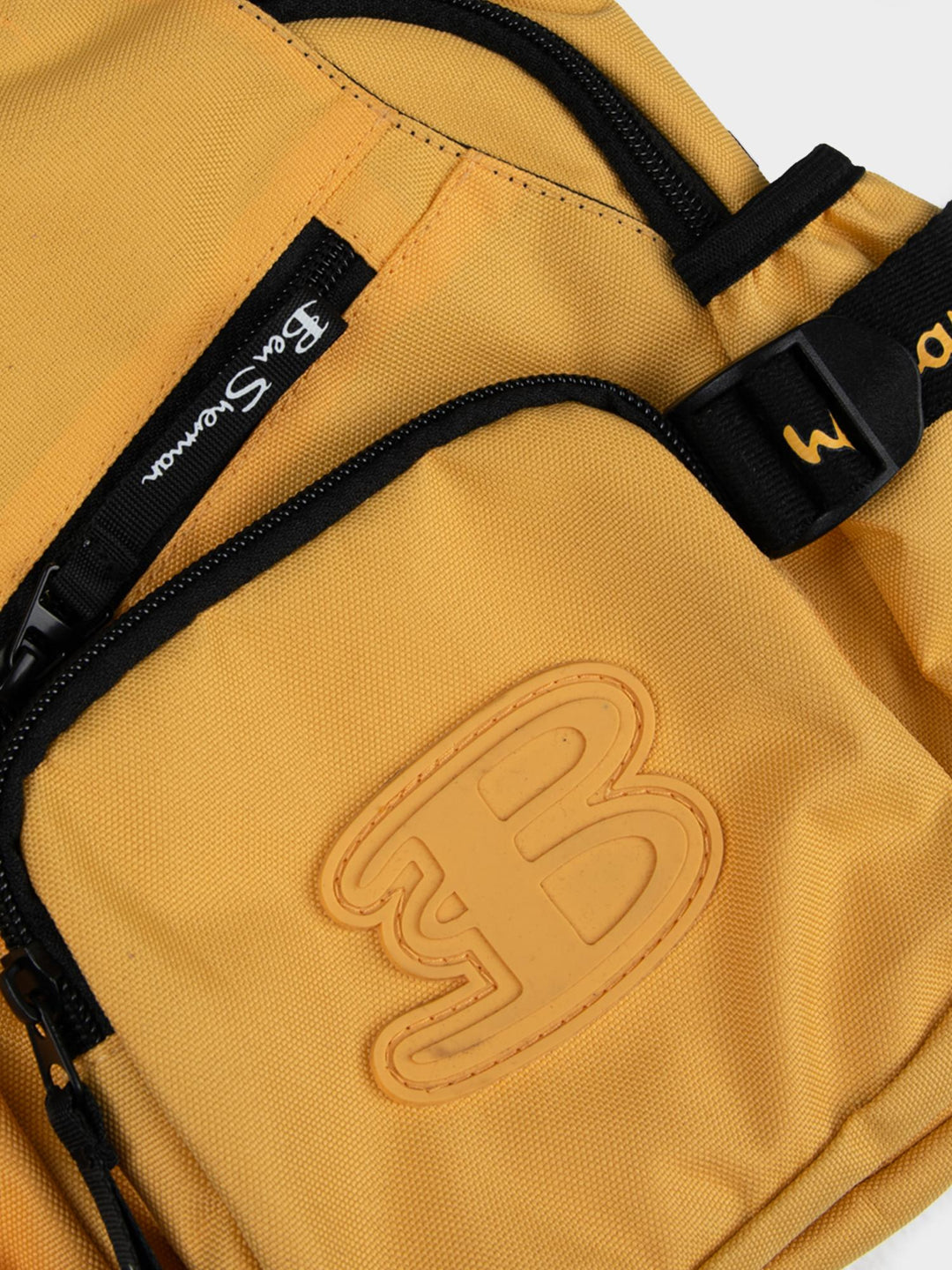 Ben Sherman Chestpack Satchel Banana Yellow — close-up of canvas front pocket with embossed B logo and zip detail