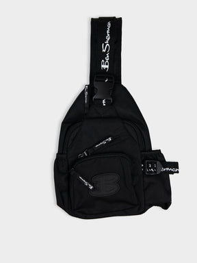 Ben Sherman Chestpack Satchel in Black — front view showing zip compartments, buckle closure and branded crossbody strap