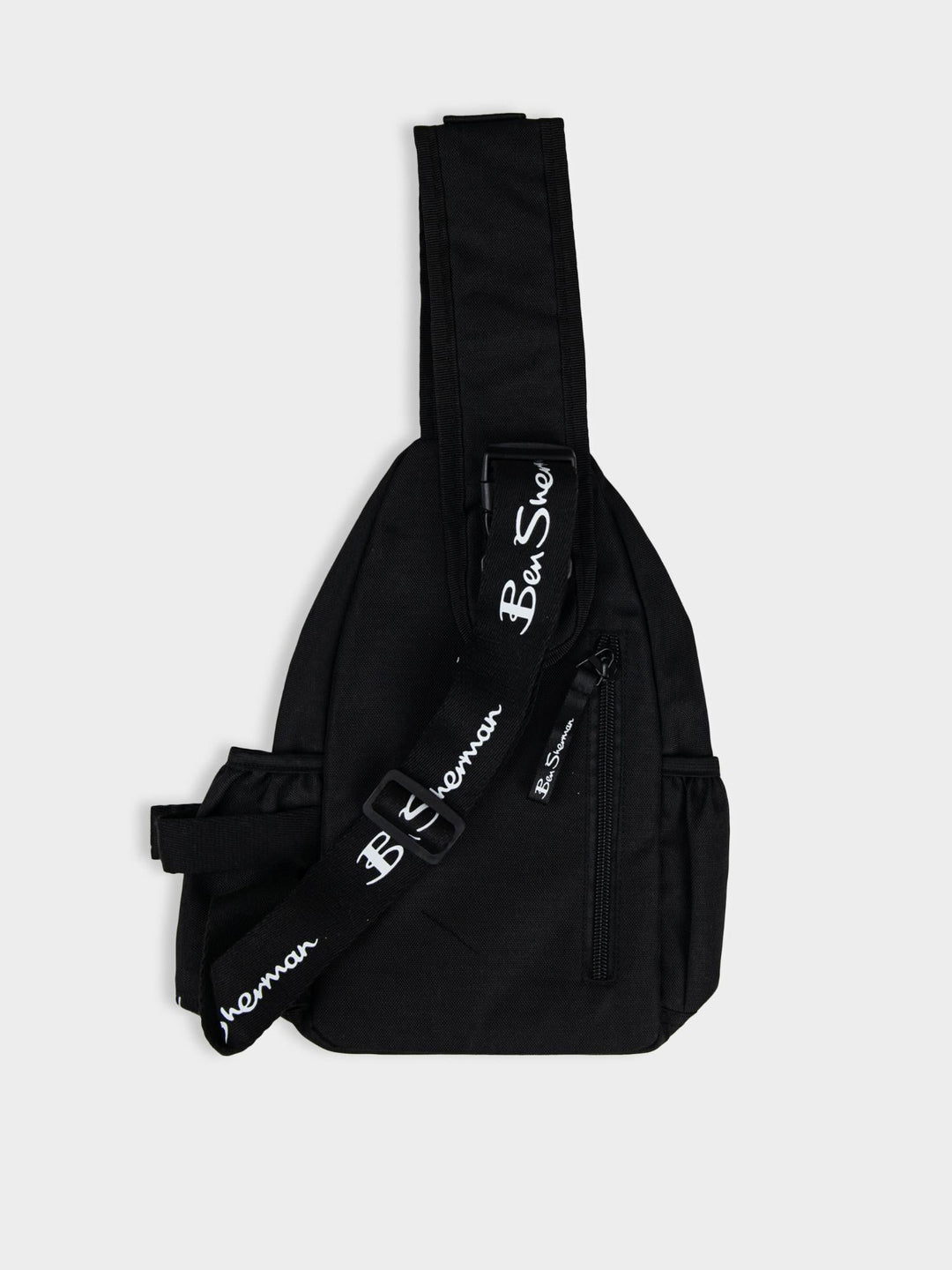 Ben Sherman Chestpack Satchel in Black — side view highlighting adjustable shoulder strap and structured canvas body