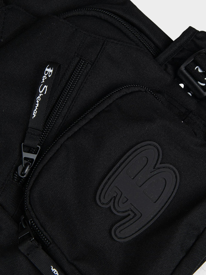 Ben Sherman Chestpack Satchel Black — close-up of canvas front pocket with embossed B logo and zip detail