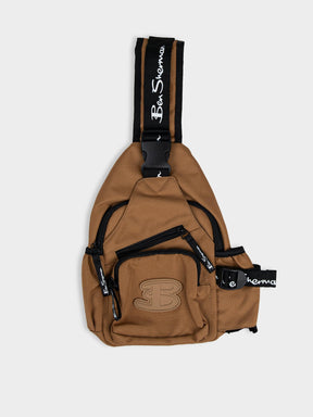 Ben Sherman Chestpack Satchel in Medal Bronze — front view showing zip compartments, buckle closure and branded crossbody strap