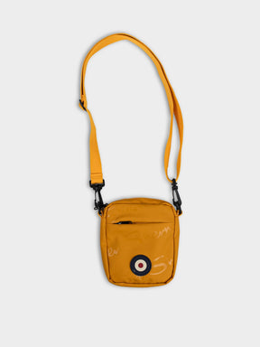 Ben Sherman Compact Crossbody Wax Plastisol Bag in Dijon with adjustable strap and Mod target emblem – front view