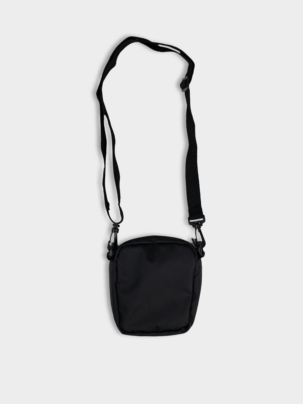 Side view of Ben Sherman Compact Crossbody Bag in Black showing adjustable strap and front pocket detail