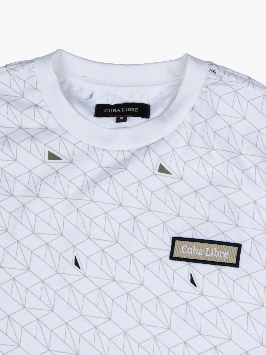 Close-up of Cuba Libre Tee in White Geo showing all-over geometric print detail and woven logo patch at chest