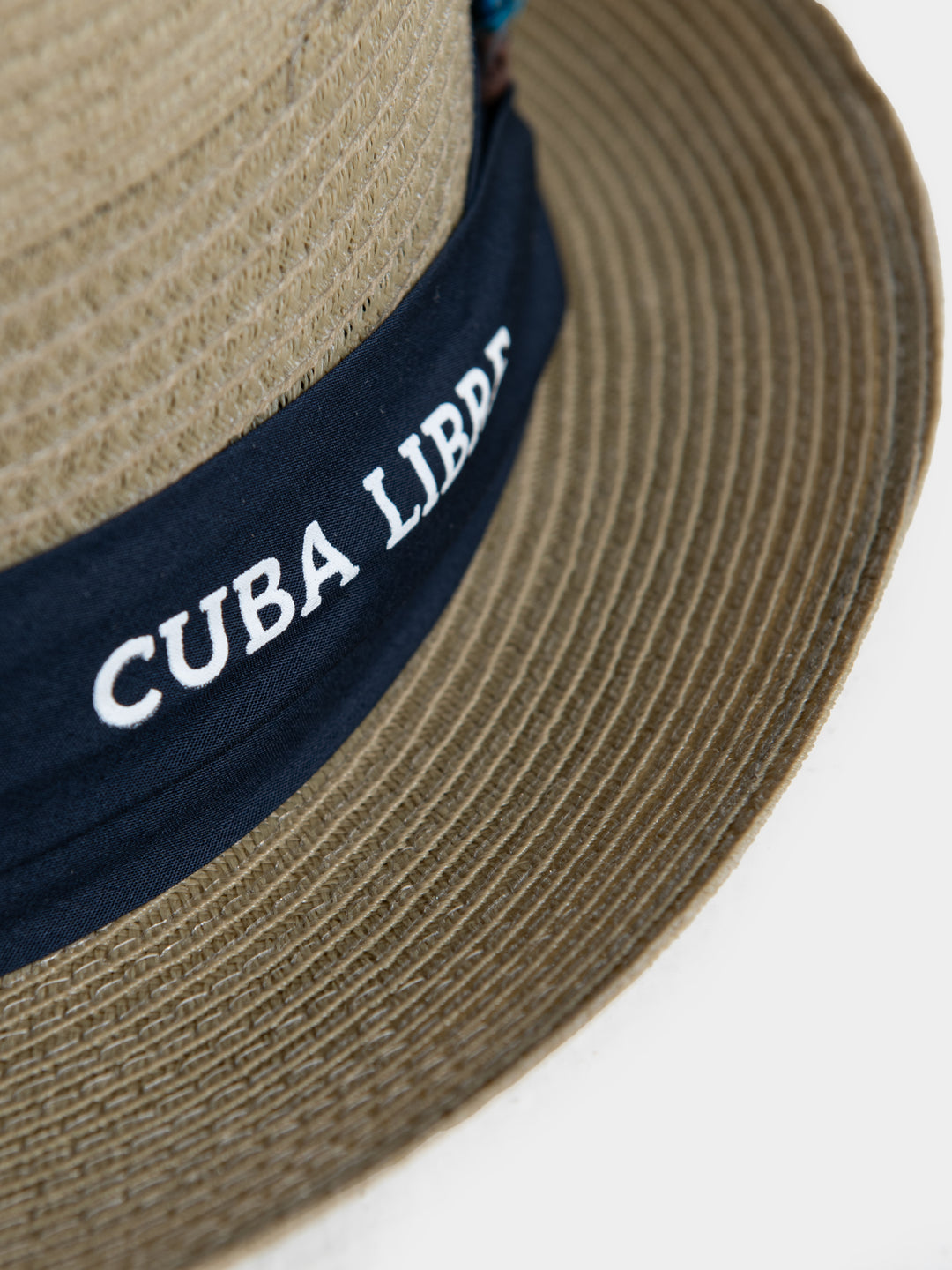 Close-up of Cuba Libre Pork Pie Hat Beige - navy band with embroidered Cuba Libre logo and feather trim detail