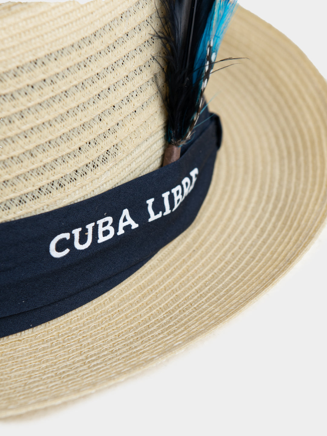 Close-up of Cuba Libre Pork Pie Hat Natural - navy band with embroidered Cuba Libre logo and blue feather trim detail