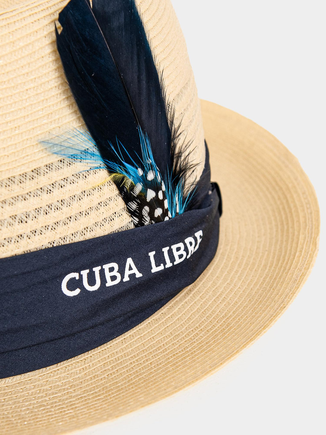 Close-up of Cuba Libre Fedora Straw Hat Natural - navy band with embroidered Cuba Libre logo and feather trim detail