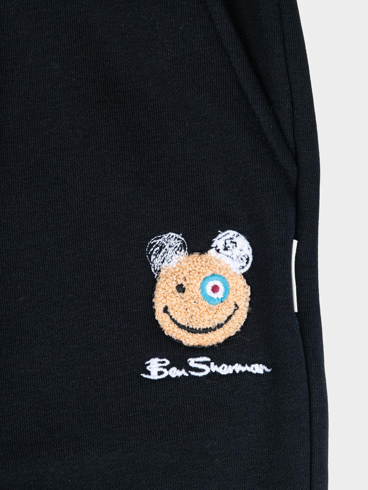 Close-up of embroidered Happy Bear motif and Ben Sherman logo on black fleece jog shorts