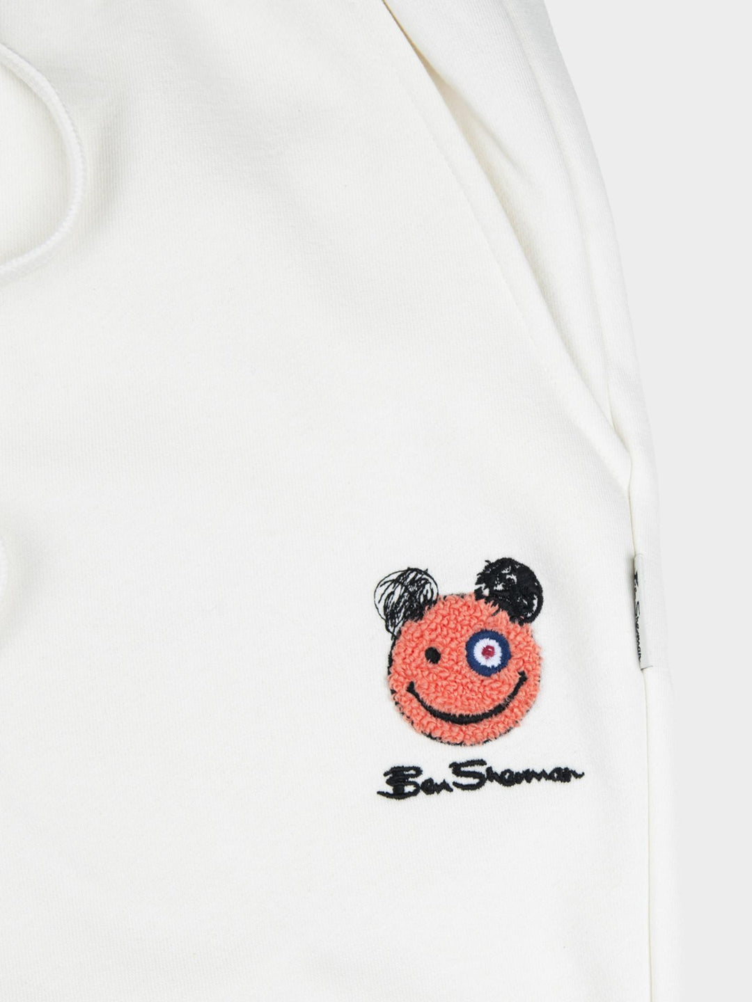 Ben Sherman Happy Bear Fleece Jog Shorts in Off White - close-up of embroidered Happy Bear patch and Ben Sherman signature on cream fleece