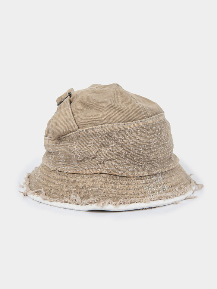 Side view of the stone Palladium frayed bucket hat in washed canvas with a frayed, distressed brim