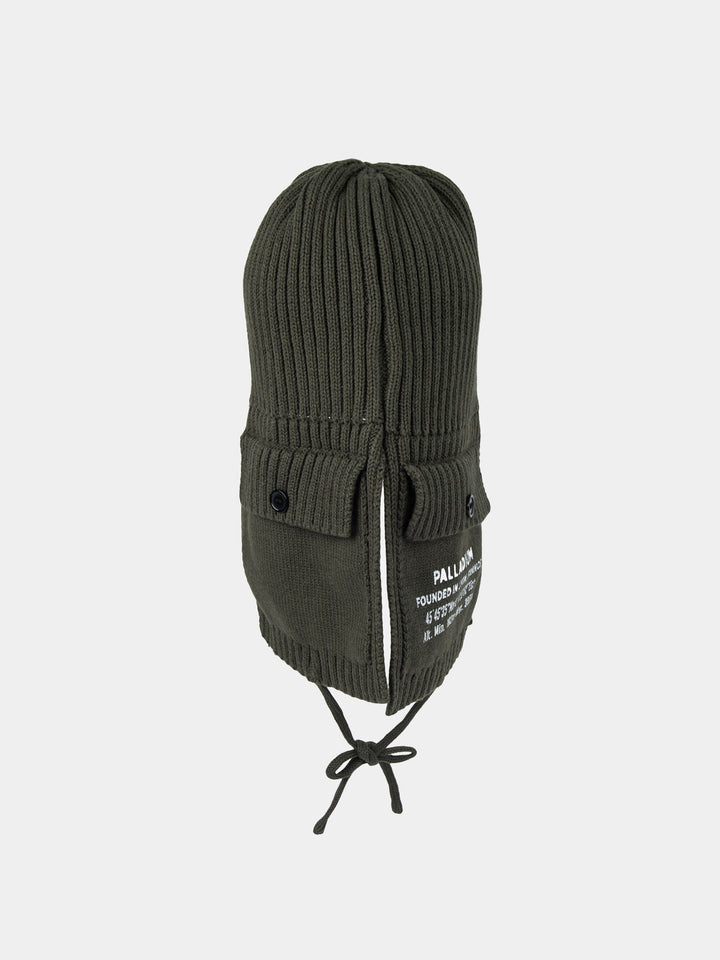 Front view of the olive Palladium Cargo trapper beanie showing button-detail side pockets, Palladium print and tie fastening