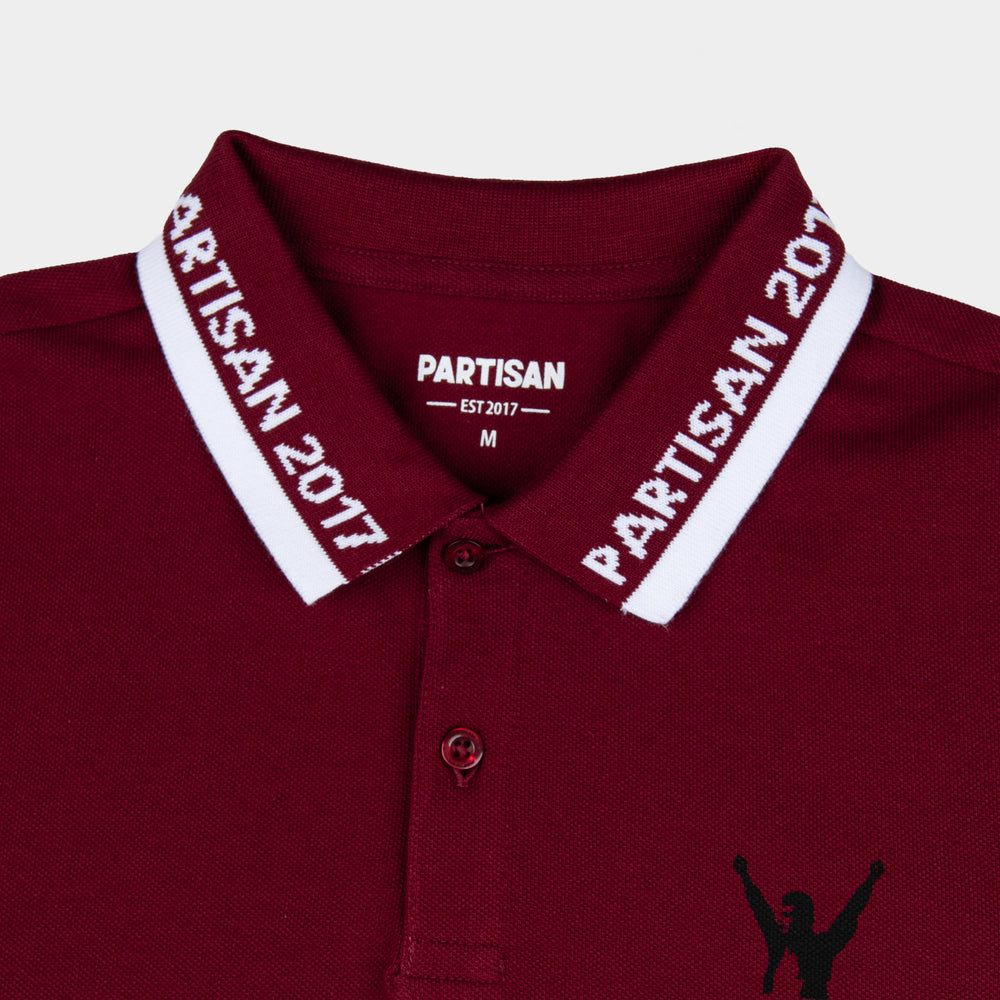 Close-up of Partisan 2017 Polo collar in Red Carpet — woven branding detail and chest emblem on deep red piqué fabric