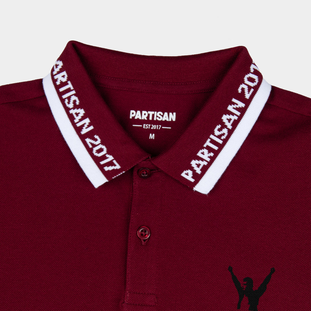 Close-up of Partisan 2017 Polo collar in Red Carpet — woven branding detail and chest emblem on deep red piqué fabric
