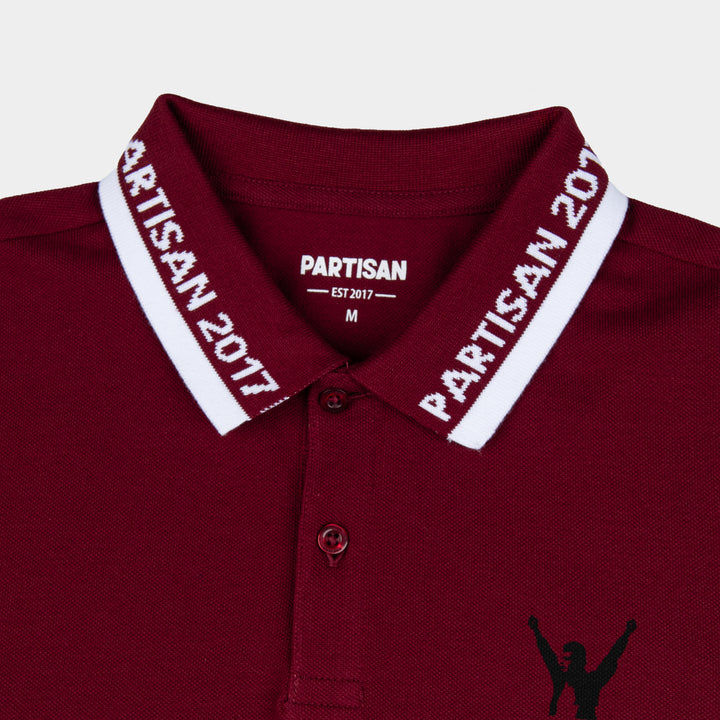 Close-up of Partisan 2017 Polo collar in Red Carpet — woven branding detail and chest emblem on deep red piqué fabric