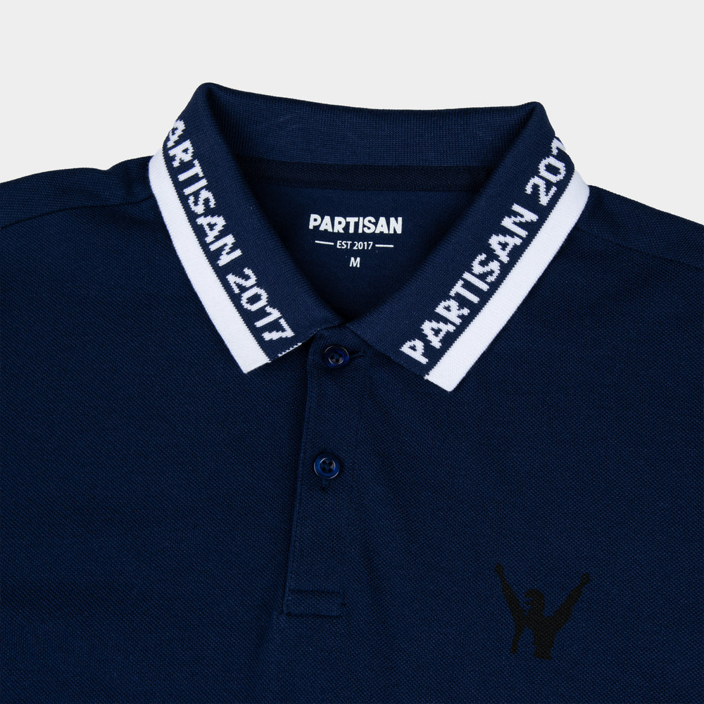 Close-up of Partisan 2017 Polo collar in Sprink Navy — woven branding detail and chest emblem on navy piqué fabric