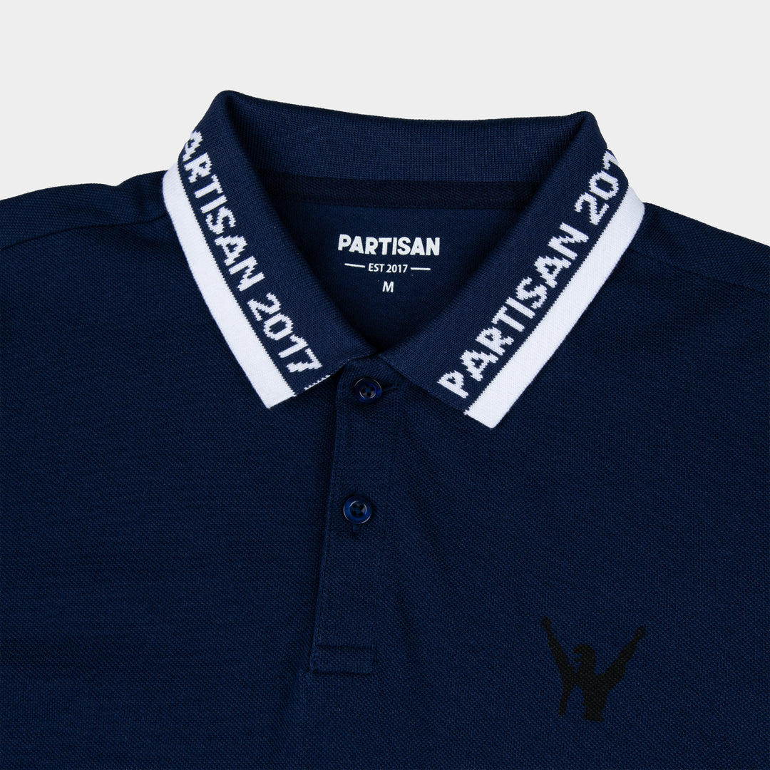 Close-up of Partisan 2017 Polo collar in Sprink Navy — woven branding detail and chest emblem on navy piqué fabric