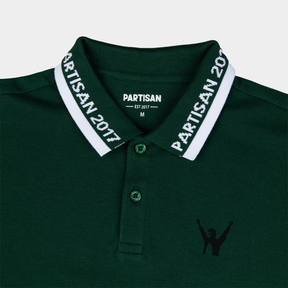 Close-up of Partisan 2017 Polo collar in Vintage Pine — woven branding detail and chest emblem on green piqué fabric