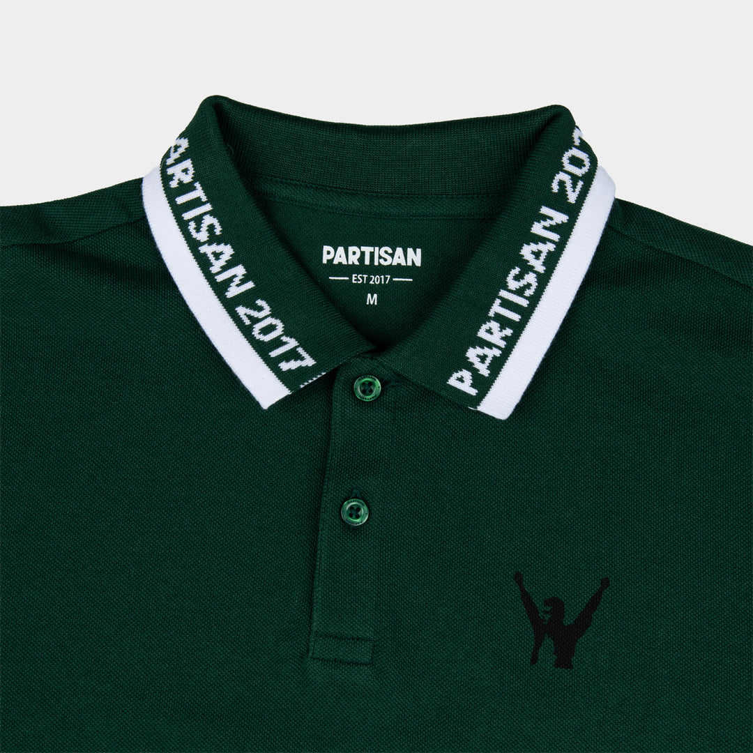Close-up of Partisan 2017 Polo collar in Vintage Pine — woven branding detail and chest emblem on green piqué fabric