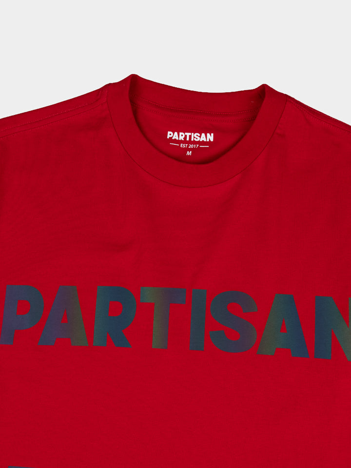 Partisan Reflective Print Tee in Red – close-up detail of the light-shifting reflective chest logo on red streetwear t-shirt by Partisan and Co
