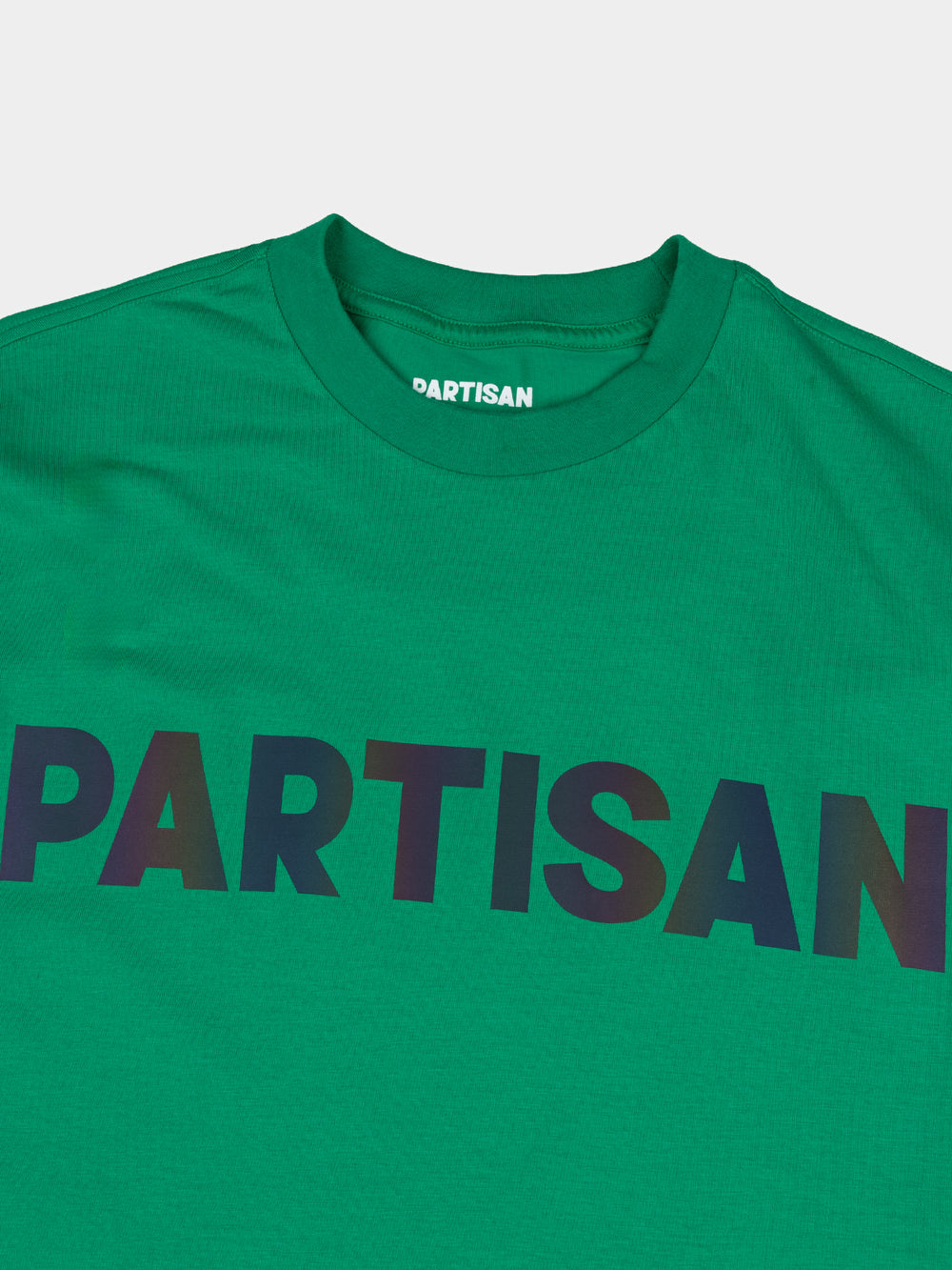 Partisan Reflective Print Tee in Staford Green – close-up detail of the light-shifting reflective chest logo on green streetwear t-shirt by Partisan and Co