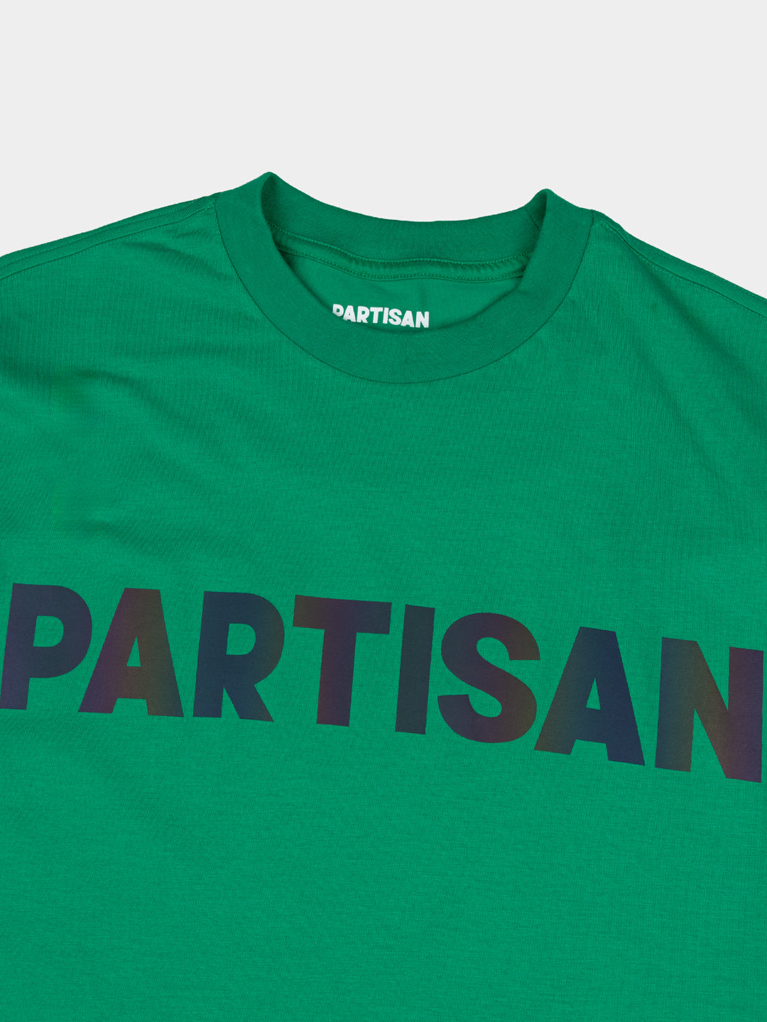 Partisan Reflective Print Tee in Staford Green – close-up detail of the light-shifting reflective chest logo on green streetwear t-shirt by Partisan and Co