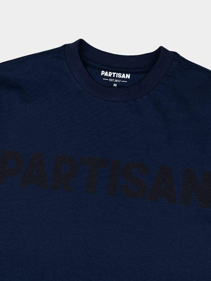 Partisan Tonal Print Tee in Navy – Close-up of tonal chest logo print and neck label on navy blue cotton t-shirt