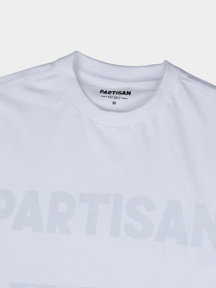 Partisan Tonal Print Tee in White – Close-up of tonal chest logo print and neck label on white cotton t-shirt