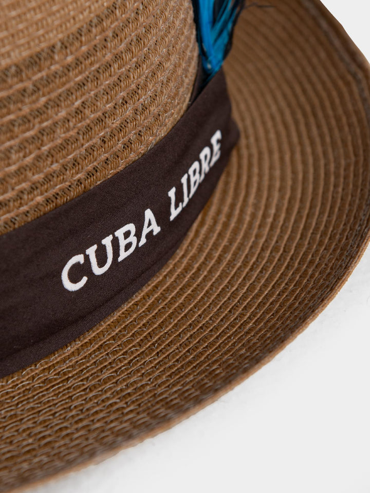 Close-up of Cuba Libre Pork Pie Hat Gold - dark band with embroidered Cuba Libre logo and blue feather trim detail