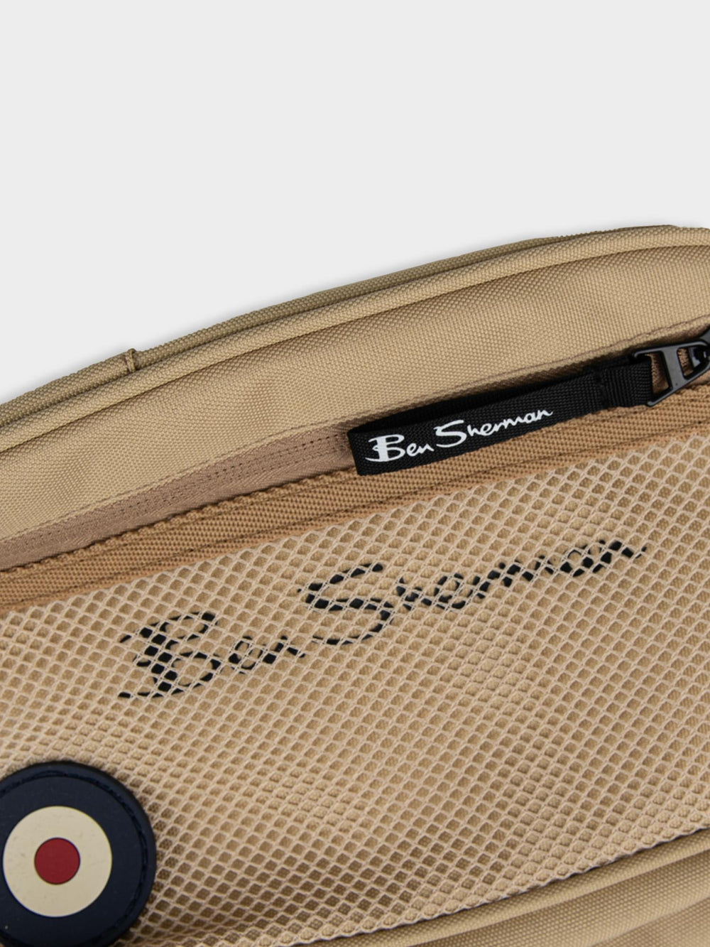 Close-up top view of Ben Sherman Satchel Crossbody in New Wheat showing front mesh pocket, zip closure and Ben Sherman logo detail
