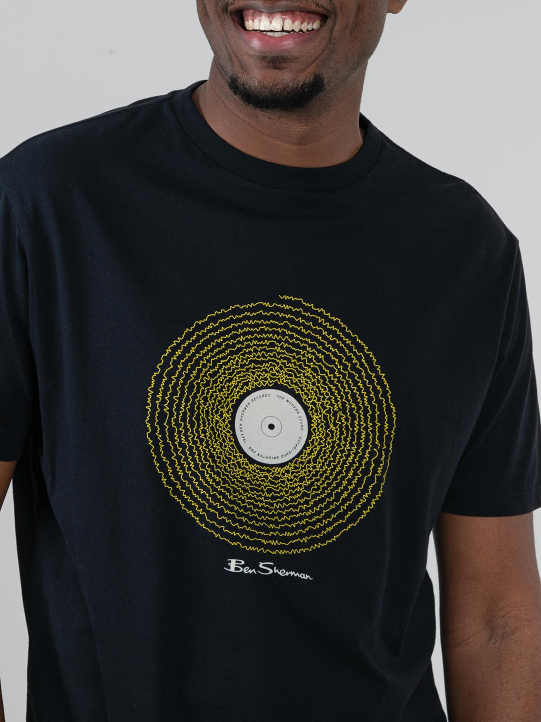 Close-up of Ben Sherman Sound Wave Graphic Tee in Black – intricate gold vinyl record chest print with Ben Sherman signature on bold black cotton