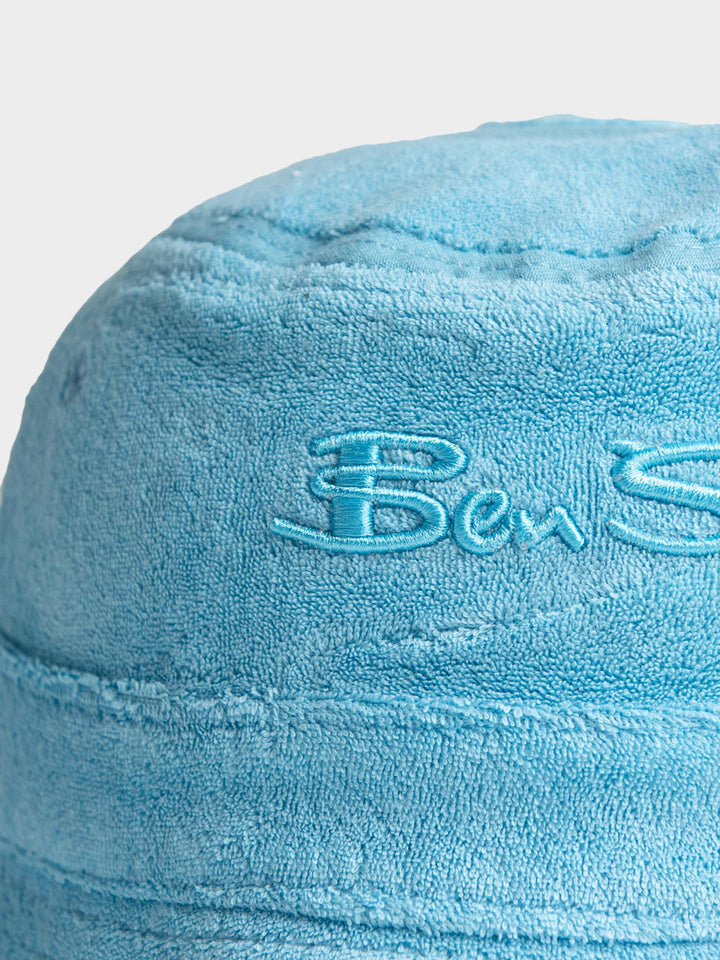 Ben Sherman Target Towelling Bucket Hat in Retro Blue - close-up of tonal embroidered Ben Sherman logo on soft blue terrycloth