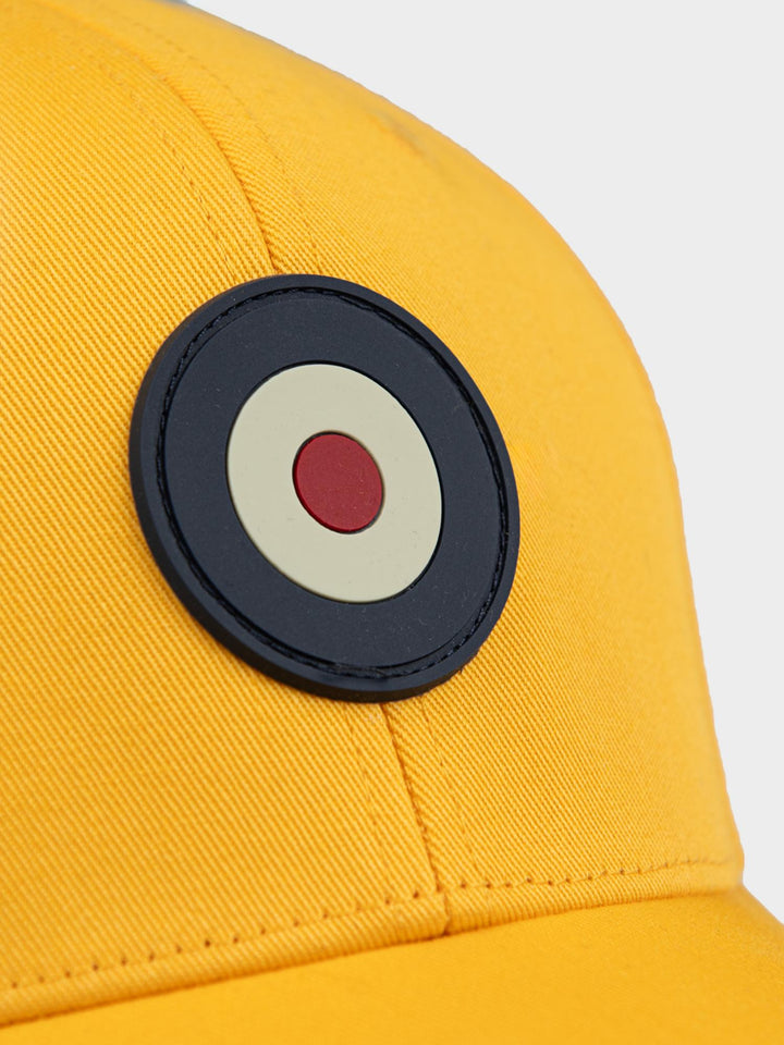Ben Sherman Targy Peak Cap in Banana - close-up of rubberized Target EMB emblem on yellow cotton fabric