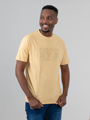 Ben Sherman Trio Embossed Bears graphic T-shirt in New Wheat, worn by a smiling male model on a light grey background