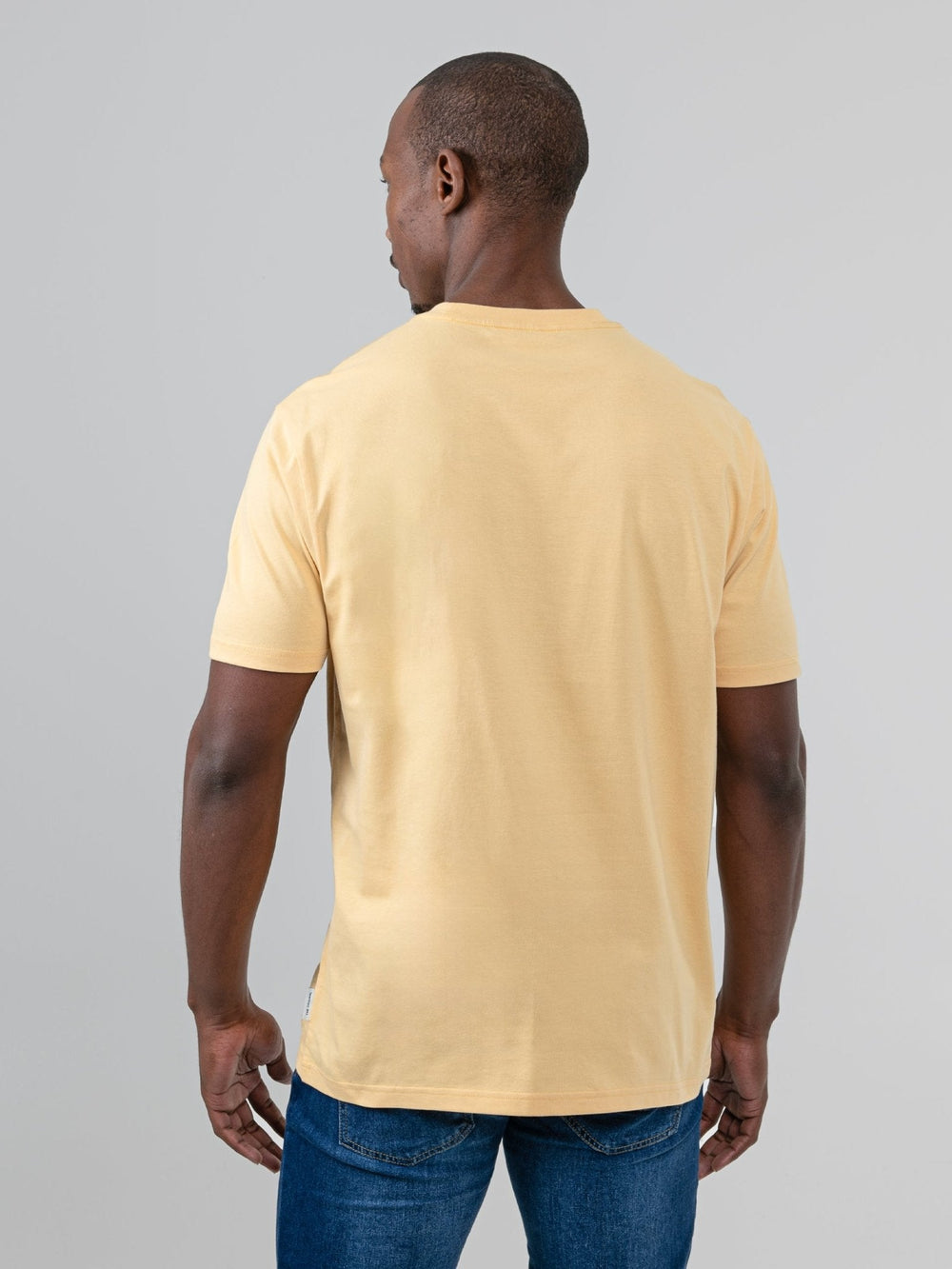 aBen Sherman Typography Headphones Tee New Wheat - back view on model showing plain wheat cotton back panel, styled with jeans