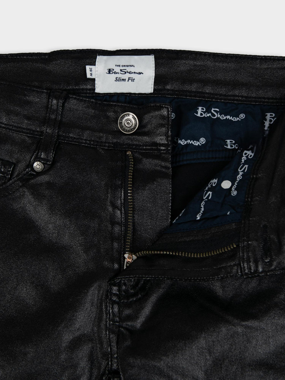 Ben Sherman Wax Coated Sheen Slim Fit Denim in Black - close-up detail of Ben Sherman branded label, zip fly and button fastening with wax-sheen finish