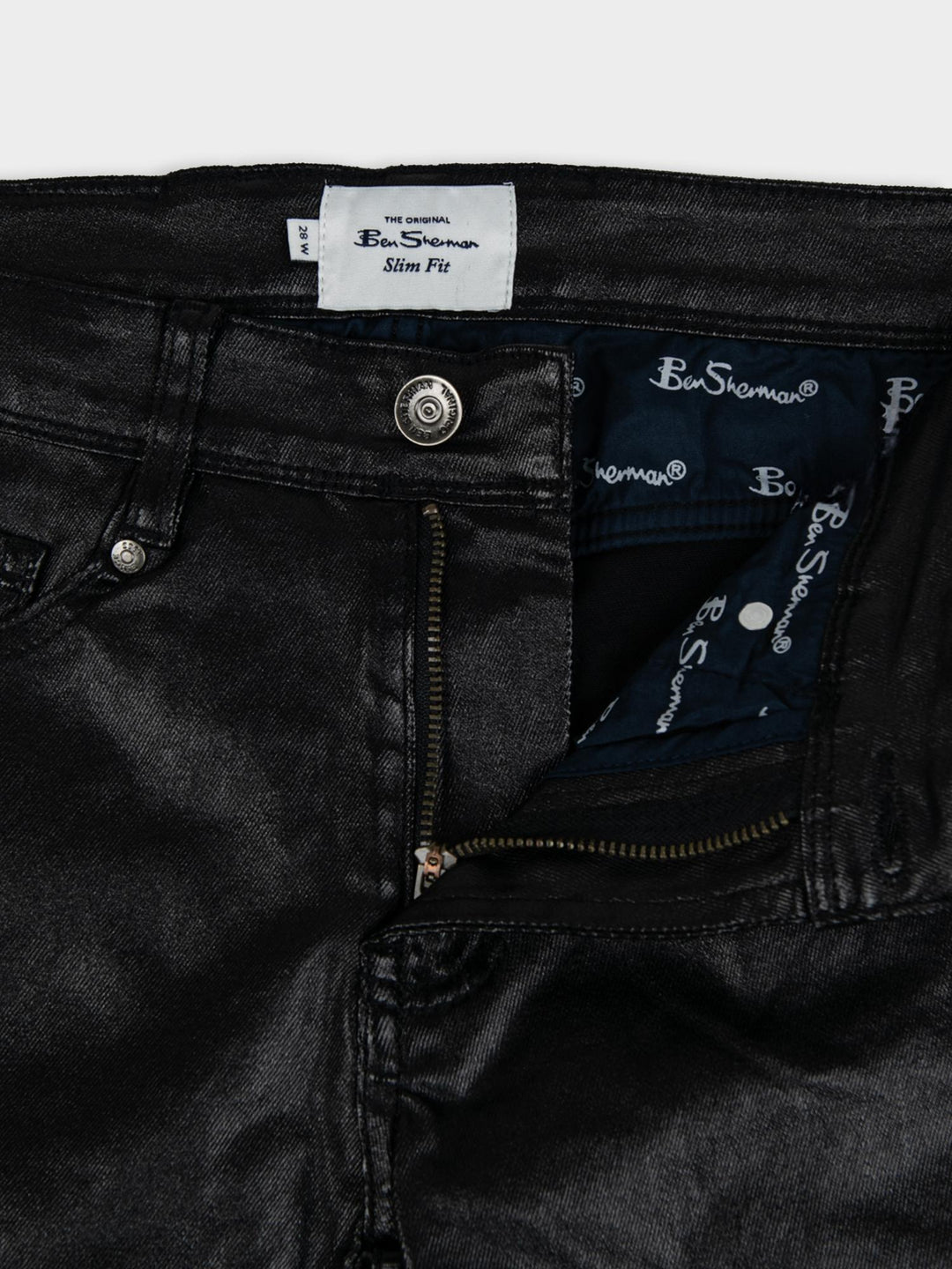 Ben Sherman Wax Coated Sheen Slim Fit Denim in Black - close-up detail of Ben Sherman branded label, zip fly and button fastening with wax-sheen finish
