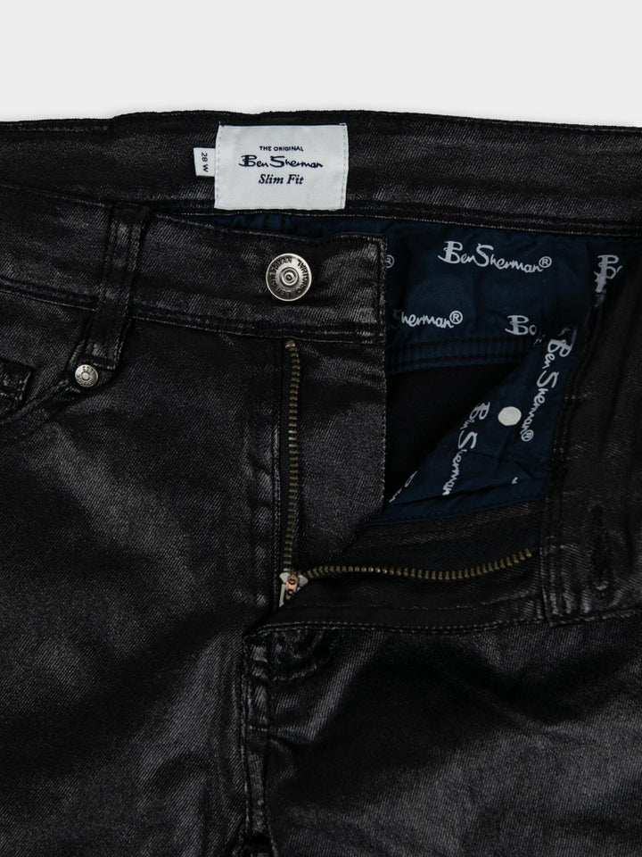 Ben Sherman Wax Coated Sheen Slim Fit Denim in Black - close-up detail of Ben Sherman branded label, zip fly and button fastening with wax-sheen finish